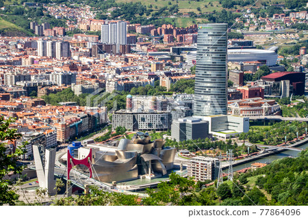 Spain, aerial view of Bilbao. Bilbao Stadium, Guggenheim Museum, Iberdrola Bridge and Tower 77864096