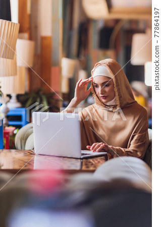 Beautiful Arabic business woman working on computer. 77864197
