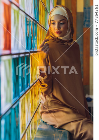 Arabian young muslim woman sitting in a cafe. Arabian young muslim woman sitting in a cafe. 77864261