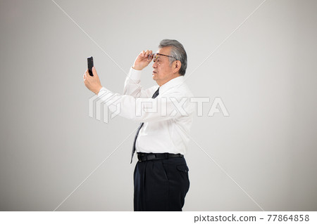 Businessman smartphone senior presbyopia 77864858