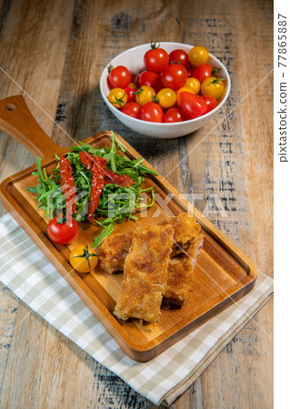 Calf escutcheon recipe for Milanese, Parmesan, Roquette and candied tomatoes Calf escutcheon recipe for Milanese, Parmesan, Roquette and candied tomatoes 77865887