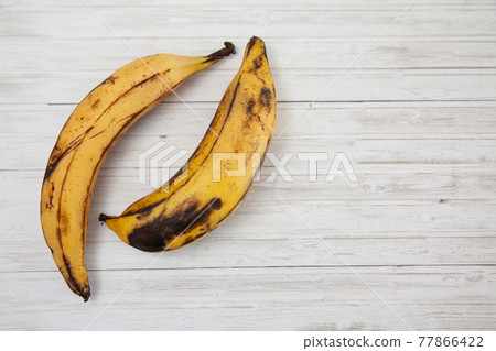 Plantain or Green Banana (Musa x paradisiaca) on white wooden background 77866422