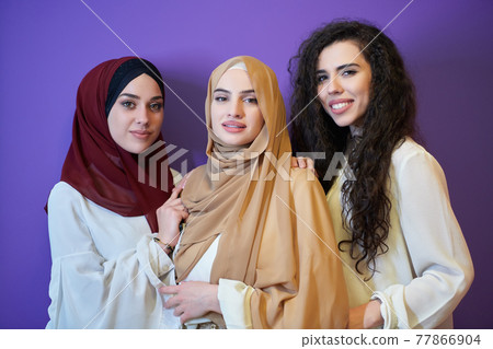 Young muslim women posing on purple background 77866904