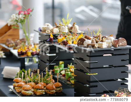 Food court. A set of catering dishes, food on a black plate. 77868079