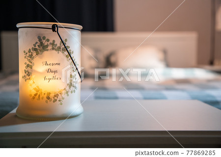 cozy bedroom detail focus on burning candle 77869285