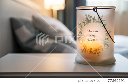 cozy bedroom detail focus on burning candle 77869291