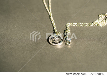Couple set pendant necklace for lovers shoot outdoors in a sunny day closeup. Selective focus Couple set pendant necklace for lovers shoot outdoors in a sunny day closeup. Selective focus 77869892