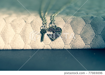 Couple set pendant necklace with a key and a heart for lovers closeup. Selective focus 77869896