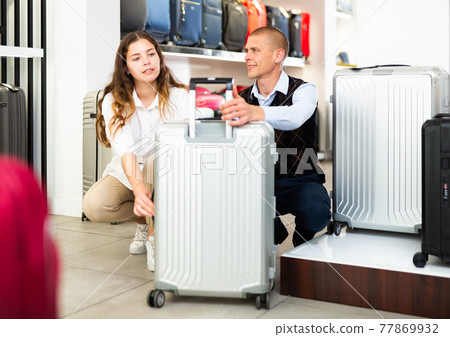 Couple choosing travel suitcase in shop Couple choosing travel suitcase in shop 77869932