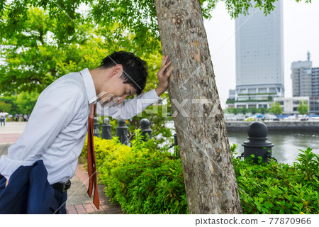 Business man resting in the shade of trees Minatomirai Yokohama 77870966