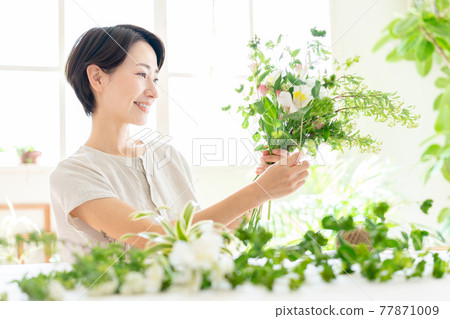 享受花的佈置的婦女 77871009
