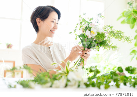 A woman enjoying a flower arrangement A woman enjoying a flower arrangement 77871015