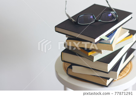 堆積的書和眼鏡 77871291