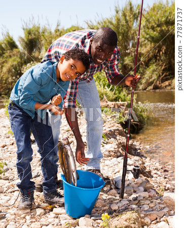 Man and boy with bucket of catch Man and boy with bucket of catch 77871737