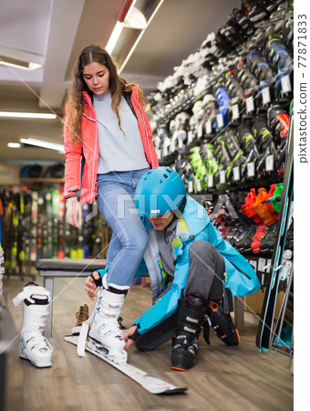 male and female are trying on boots for skiing male and female are trying on boots for skiing 77871833