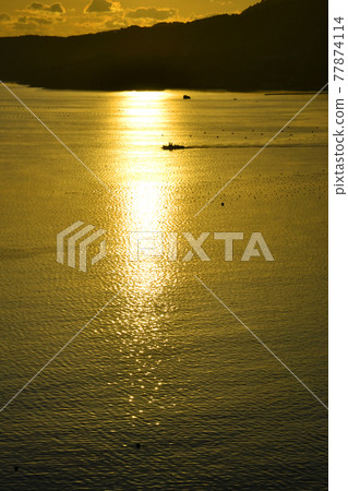 Fishing boat sailing at sunrise 77874114