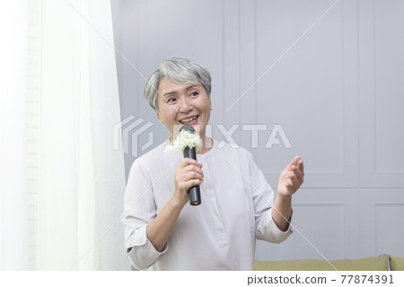 拿麥克風歡唱的高齡女士 拿麥克風歡唱的高齡女士 77874391