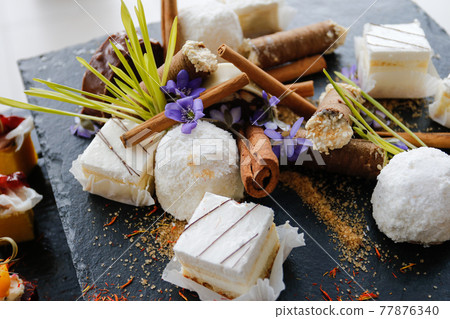 Set of sweet desserts for catering, dessert on a black plate. Set of sweet desserts for catering, dessert on a black plate. 77876340