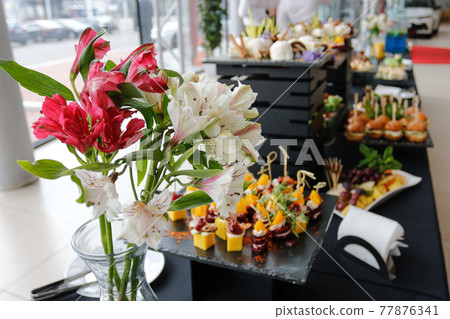 Food court. A set of catering dishes, food on a black plate. 77876341