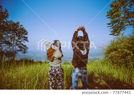 Couples travel nature. Travel relax. Standing natural touch grass on the Mountain Couples travel nature. Travel relax. Standing natural touch grass on the Mountain 77877443