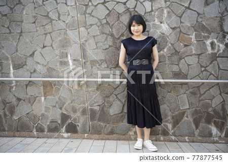 A young woman leaning on the railing of an underpass slope 77877545