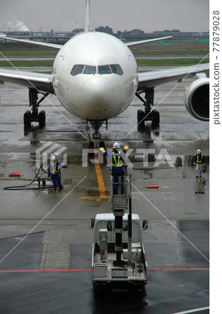 Airplane guided after arriving at the rainy airport Airplane guided after arriving at the rainy airport 77879028