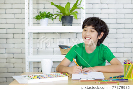 Asian boy draw and color on wooden table. Enjoy leisure weekend at home. Stress free concept Asian boy draw and color on wooden table. Enjoy leisure weekend at home. Stress free concept 77879985