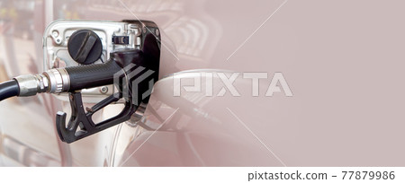 Black diesel gas pump nozzle filling up bronze pickup truck tank. Close up Black diesel gas pump nozzle filling up bronze pickup truck tank. Close up 77879986