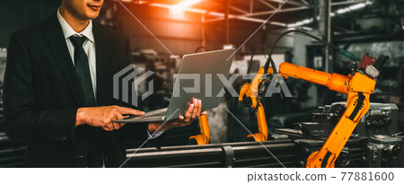 Engineer use advanced robotic software to control industry robot arm in factory Engineer use advanced robotic software to control industry robot arm in factory 77881600