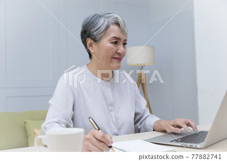 Elderly professional woman working from home during covid-19 pandemic Elderly professional woman working from home during covid-19 pandemic 77882741