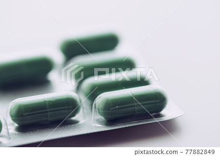 Green pills and capsules as nutrition supplement, wellness and healthcare 77882849