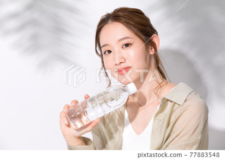 拿著一個塑料瓶水的水合的少婦 77883548
