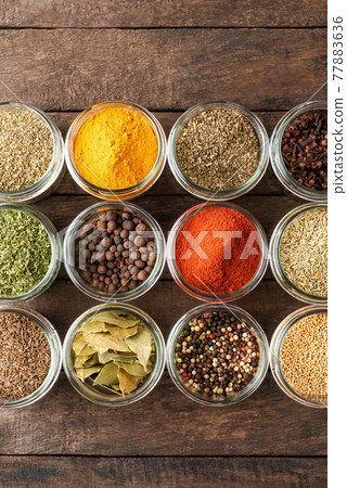 Various kinds of spices in bowls on wooden table. Top view 77883636