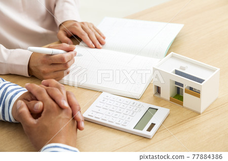 A couple who keeps a household account book 77884386