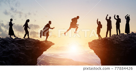 Business and Challenge Businessmen jumping over valleys Business and Challenge Businessmen jumping over valleys 77884426