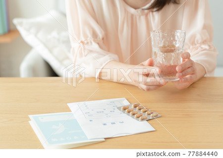 Middle-aged women taking medicine 77884440