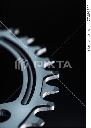 Star teeth pattern with bicycle chain mechanisms on black background. Star teeth pattern with bicycle chain mechanisms on black background. 77884791