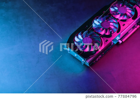 A graphics card with a row of fans with a cyanotic purple backlight in a futuristic design. A graphics card with a row of fans with a cyanotic purple backlight in a futuristic design. 77884796