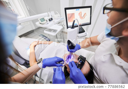 Doctor scanning patient mouth with modern intraoral scanner. 77886562