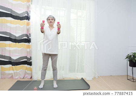 Seniors doing yoga and aerobics at home 77887415