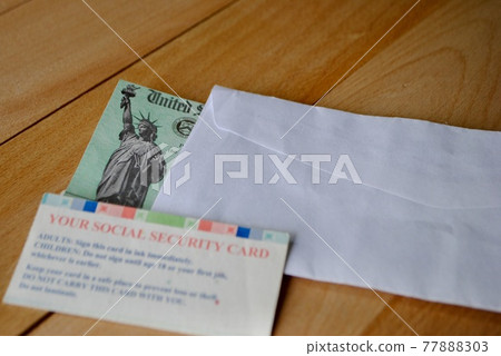 The US federal stimulus check showing the statue of liberty with envelop next to social security card. People with SSN receive the Covid 19 pandemic Economic Impact Payments. Relief Program concept.  77888303
