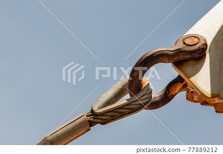 Steel turnbuckle and sling steel or Steel Wire Rope Sling and metal cable clamp connected with screw bolt. Device for adjusting the tension or length of cable on a blue sky background. Steel turnbuckle and sling steel or Steel Wire Rope Sling and metal cable clamp connected with screw bolt. Device for adjusting the tension or length of cable on a blue sky background. 77889212