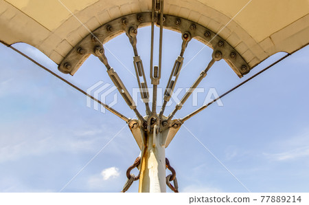 Connection points of tension membrane roof. Turnbuckle wire rope tension for tension membrane roof on a blue sky background. 77889214
