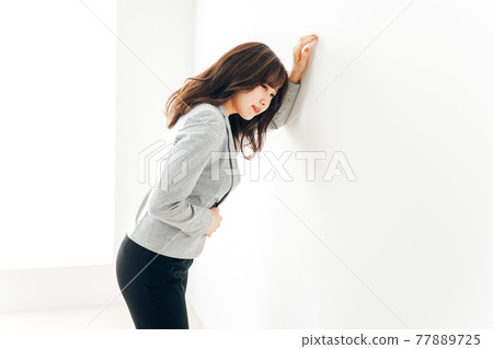 Young woman suffering from abdominal pain and menstrual cramps Young woman suffering from abdominal pain and menstrual cramps 77889725