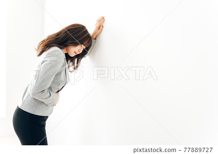 Young woman suffering from abdominal pain and menstrual cramps 77889727