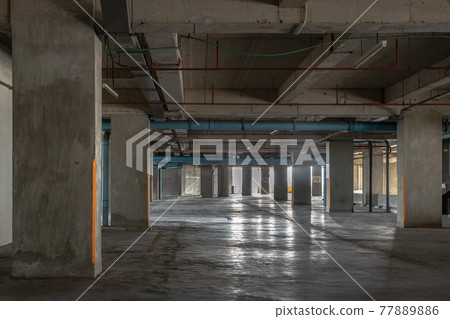 Vacant parking lot in car park building at condominium. Empty car parking garage in the afternoon. 77889886