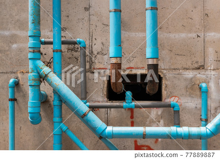 Blue water plastic pipes on the concrete wall in the condominium building. Installation of drainage pipes in the building. Sanitary system of a condominium. Water piping system install with the Blue water plastic pipes on the concrete wall in the condominium building. Installation of drainage pipes in the building. Sanitary system of a condominium. Water piping system install with the 77889887