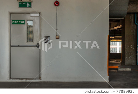 Fire exit door for emergency case with alarm for safety protection of the car parking building near the Condominium building. 77889923