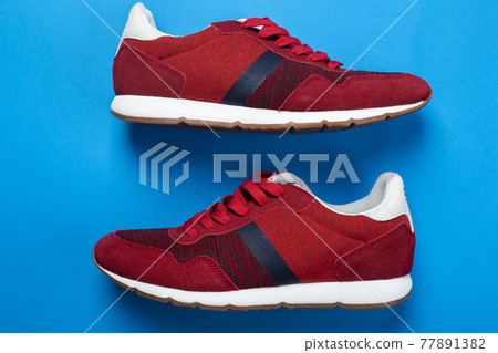 Pair of stylish red sneakers on color background, space for text. 77891382