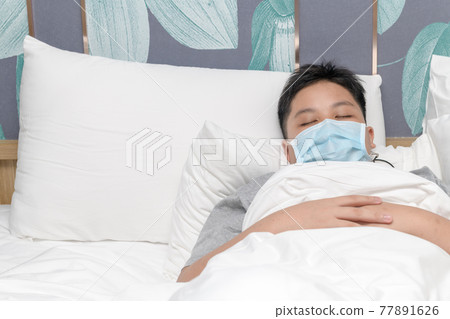 sick boy wear mask and sleep on bed, protect covid-19 77891626